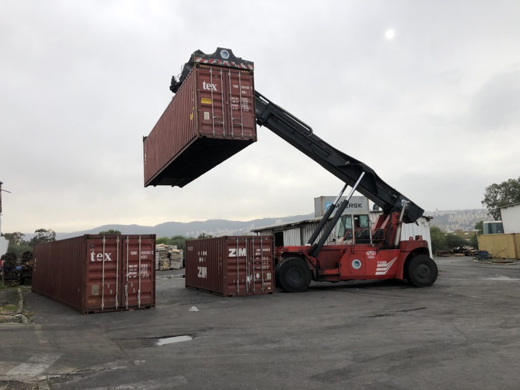 Photo of a forklift lifting a container in the air
